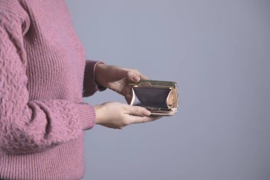 Gri arka planda kadın eli boş cüzdan