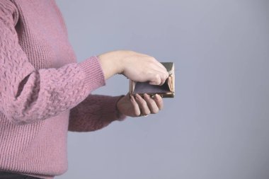 Gri arka planda kadın eli boş cüzdan