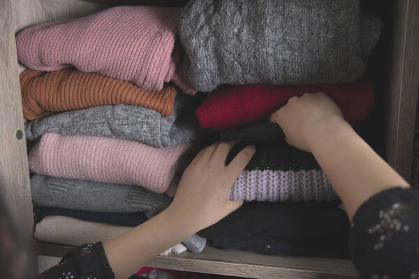 woman  arranges clothes in the close