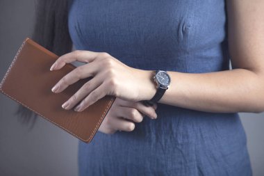 Gri arka planda saati olan kadın el defteri.