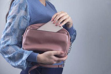 Akıllı telefonlu pembe çantalı kadın.