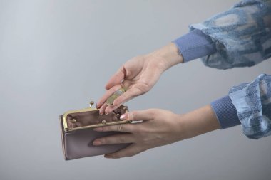 Kadın cüzdanı bozuk paralarla tutuyor.