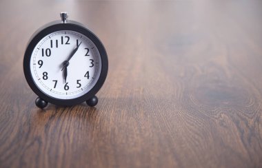 Ahşap masa arkaplanındaki saat