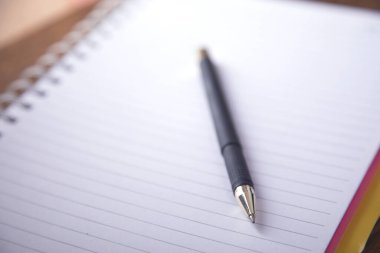 Masa arkasında not defteri olan kalem