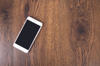 Masa arkasındaki beyaz akıllı telefon