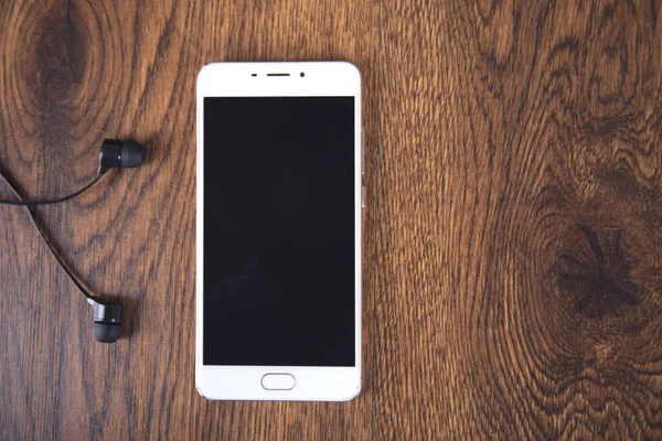 Earphone and smart phone on the table background