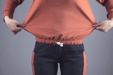 Gri duvar arka planında kilo alan kadın