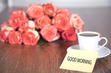 güller ve kahve ile günaydın mesajı masada