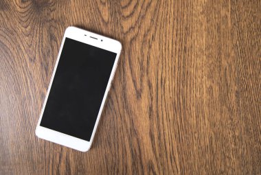 Masa arkasındaki beyaz akıllı telefon