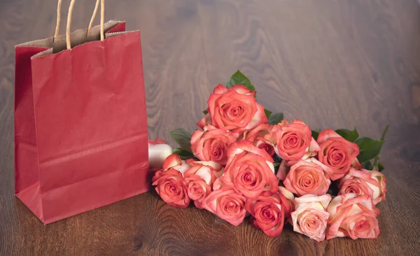 shopping bag and roses  on the table