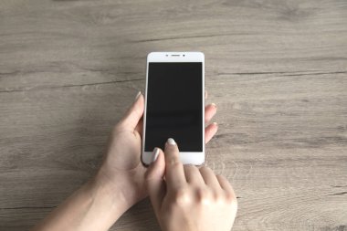 Kadın el akıllı telefonu masaya koydu.