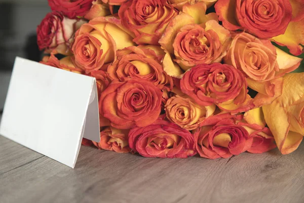 card with bouquet of roses on table