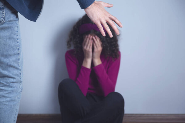 сердитый мужчина избил грустную женщину серый фон
