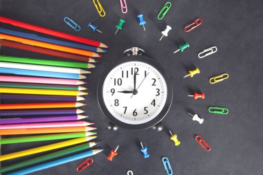 Siyah masa arkaplanındaki kırtasiye ve saat