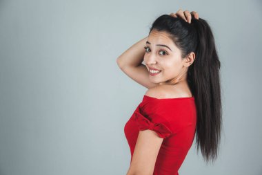 Stüdyoda gri arka planda genç ve mutlu bir kadın