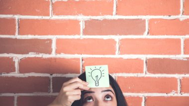 Duvarın arkasındaki kadın kafasında kağıt üzerinde ampul