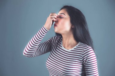 Kadın, arka planda burnu ağrıyor.