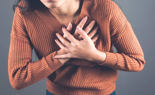 woman hand in ache heart on dark background