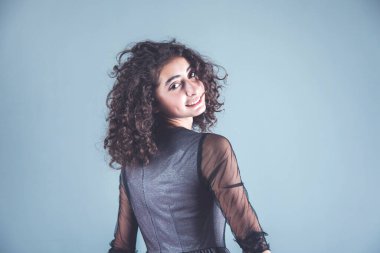 Gri arka planda genç mutlu kadın