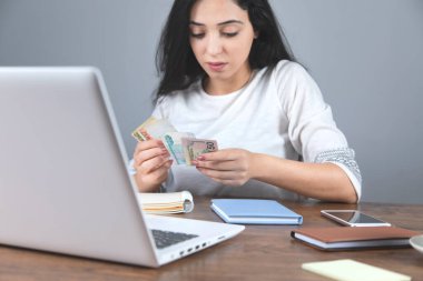 Masasında bilgisayar ekranı olan bir kadın.