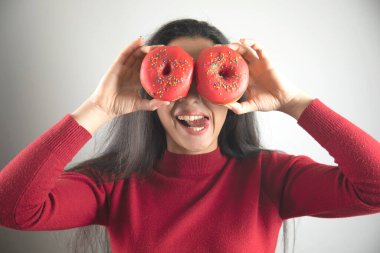 Mutlu kadın Gri arka planda donut 'ı gözüne kestirdi