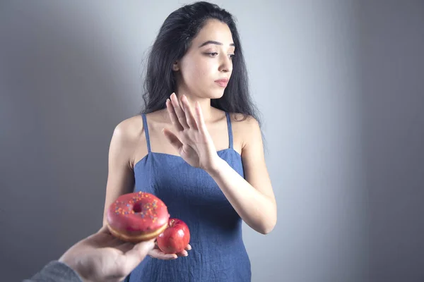 woman hand stop sign in donut on grey background