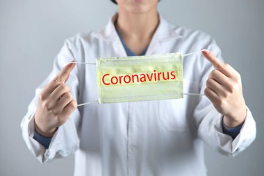 Kadın doktor el maskesi ve Coronavirus metni.