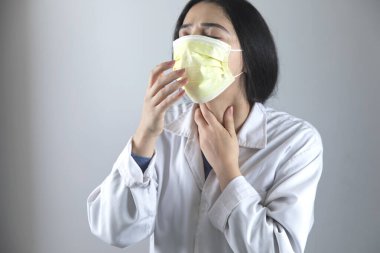 Gri arka planda genç kadın doktor gribi