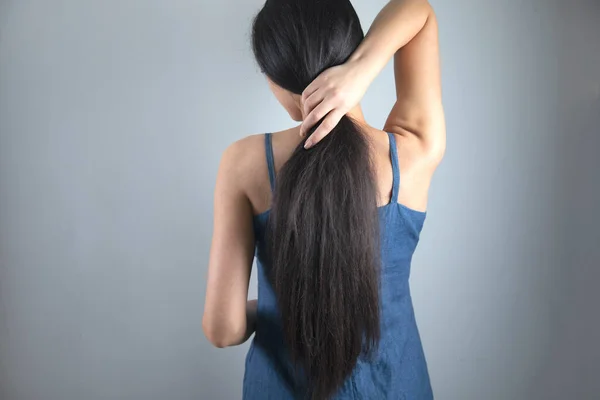 Gri Arka Planda Uzun Saçlı Bir Kadın Dokunuyor — Stok fotoğraf