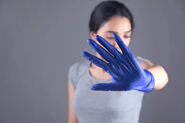 Женщина Рука Синяя Перчатка Стоп Знак Сером Фоне — стоковое фото