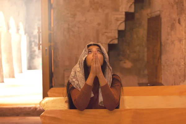 教会の背景にいる若い祈りの女性 — ストック写真