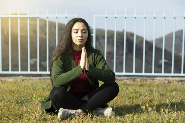 meditating woman to the ground in nature background