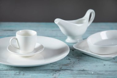 mavi ahşap masadaki farklı beyaz tabaklar.