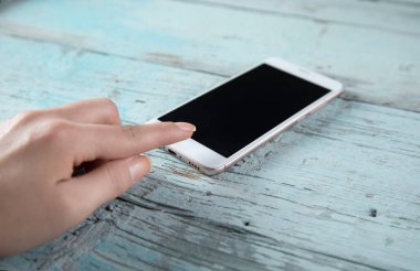 Mavi masadaki kadın el akıllı telefonu.