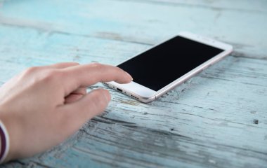 Mavi masadaki kadın el akıllı telefonu.