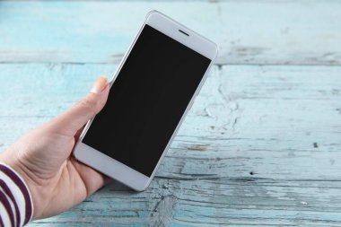 Mavi masadaki kadın el akıllı telefonu.