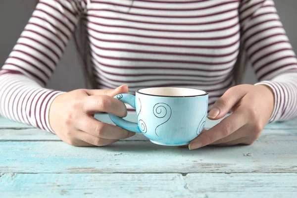 woman hand cup of coffee on the blue table