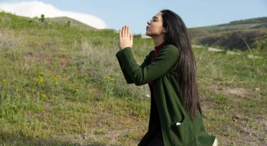 Doğadaki genç dua eden kadın.