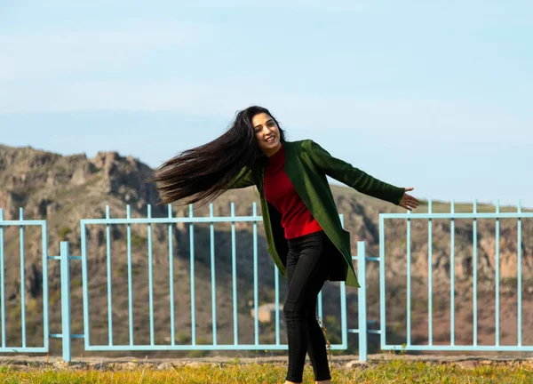 young happy woman in the mountain background