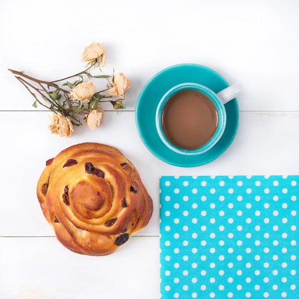 Ранкова чашка кави і булочка з родзинками . — стокове фото