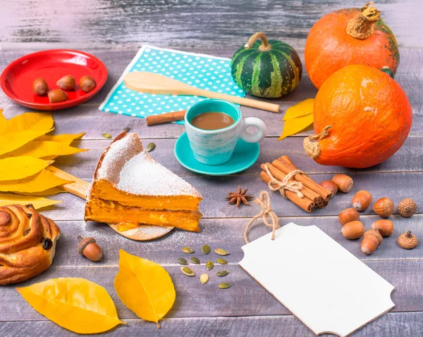 Un morceau de tarte à la citrouille avec une tasse de café parmi attribu automne — Photo