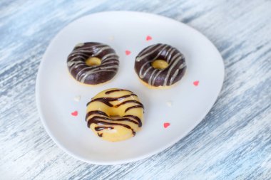 Bir plaka ışık arka plan ahşap yüzey üzerinde sır ile çörek