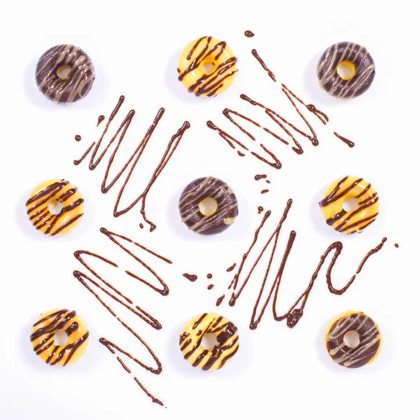 Neun Donuts auf weißer Fläche mit Schokoladendekoration — Stockfoto