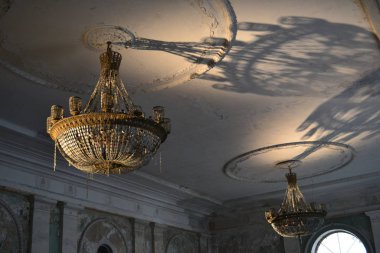 Eski bir malikanedeki kristal bir avizenin ışığı.