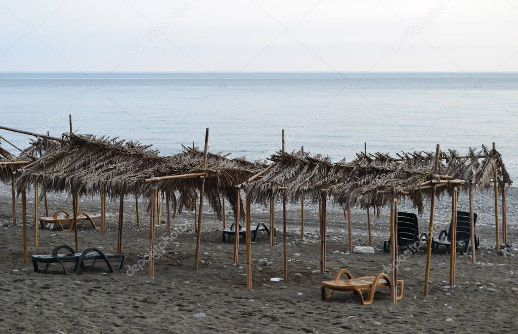 canopies with thatched roofs on a deserted beach in Pitsunda. Abkhazia.