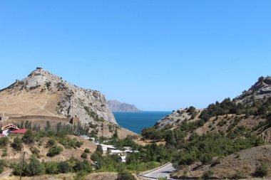 Dağların arka planında deniz manzarası