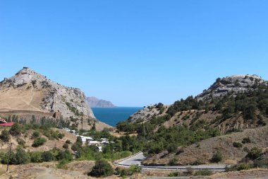 Dağların arka planında deniz manzarası