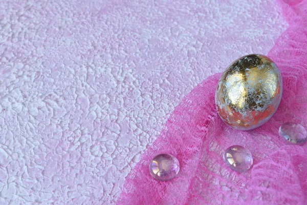 Easter egg on a pink background. Textured pink background and Golden egg