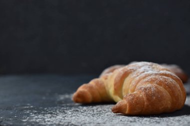 Karanlık bir arka planda kruvasan. Reklam panoları