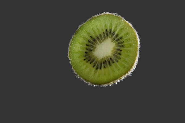Kiwi in water with bubbles. The kiwi is isolated on the grey. — Stock Photo, Image